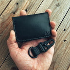 Lovecky Leather černá kožená peněženka 59 s monogramem - detail peněženky a klíčenky v ruce