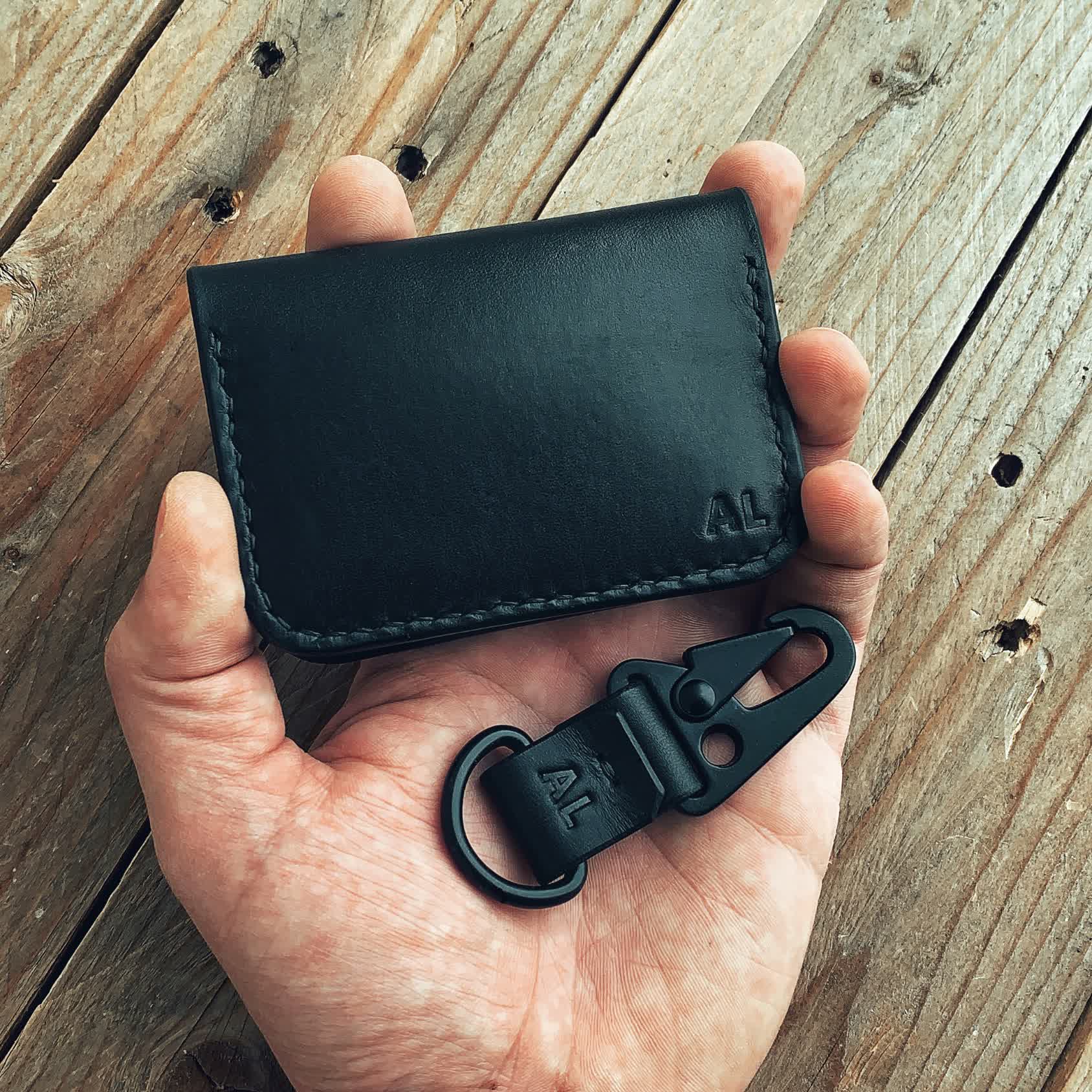 Lovecky Leather černá kožená peněženka 59 s monogramem - detail peněženky a klíčenky v ruce