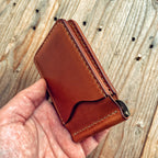 Lovecky Leather kožená dolarovka 62 s výklopnou kovovou sponou na bankovky a kapsou na karty, držená v ruce, ručně šitá z hovězí kůže