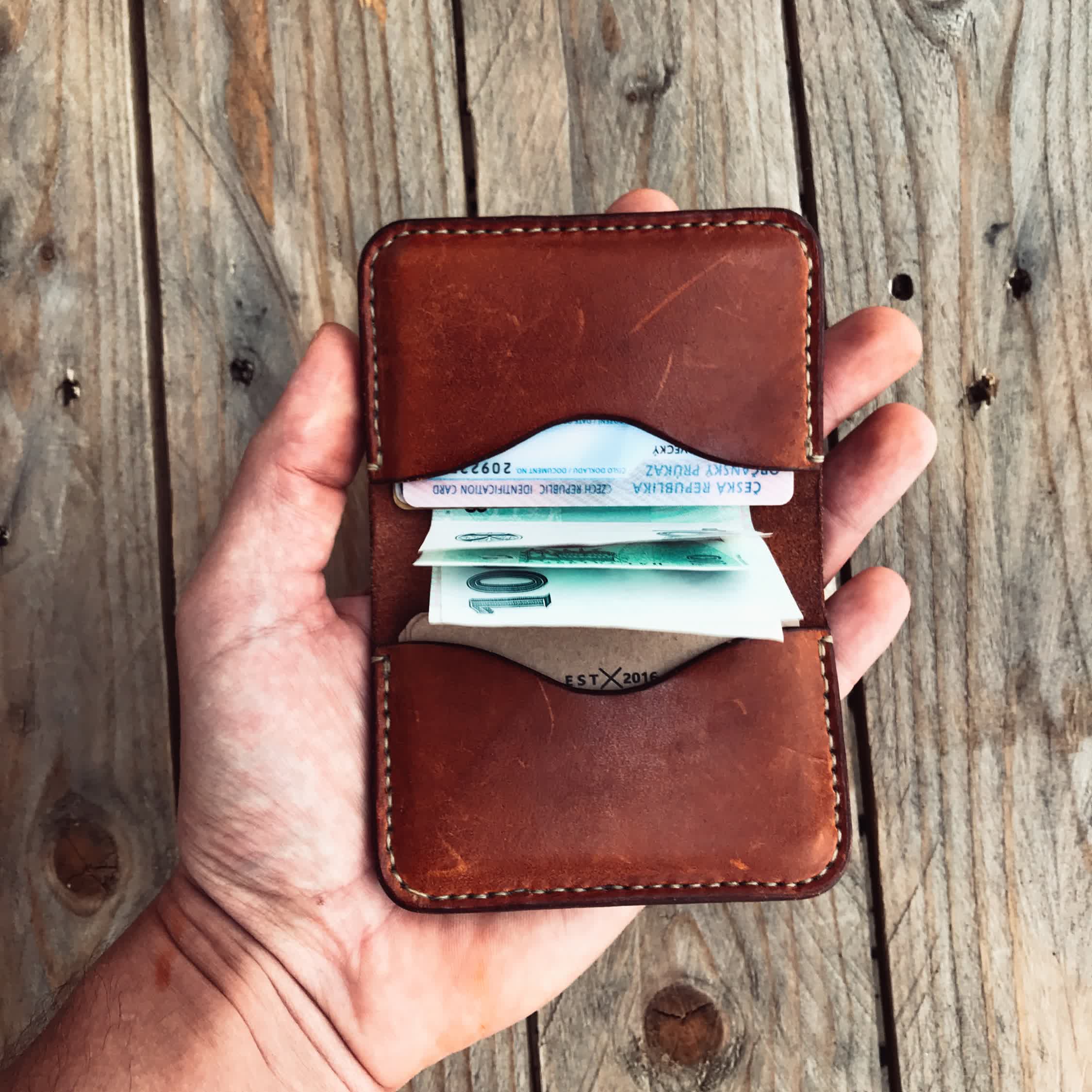 Lovecky Leather kožená peněženka 59 EDC hnědá  – otevřená v ruce, s bankovkami a doklady