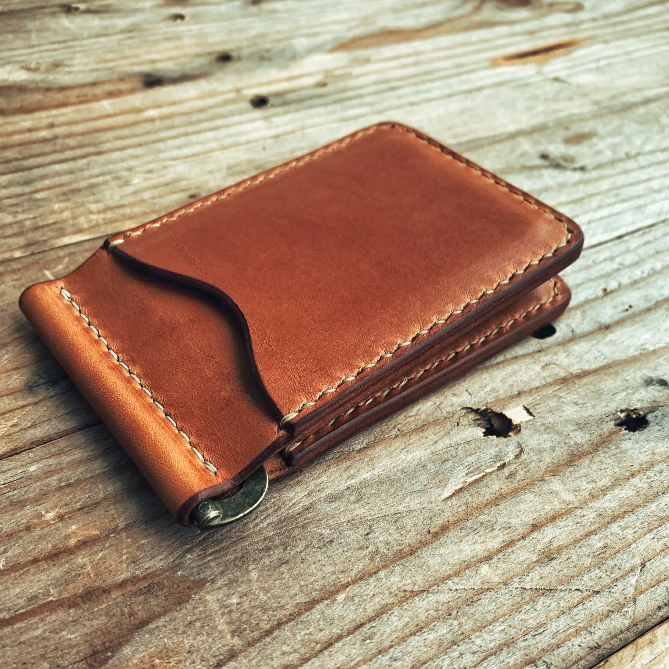 Lovecky Leather kožená peněženka 62 dolarovka, hnědá - položená na dřevěném stole, s výklopnou kovovou sponou na bankovky a kapsou na karty