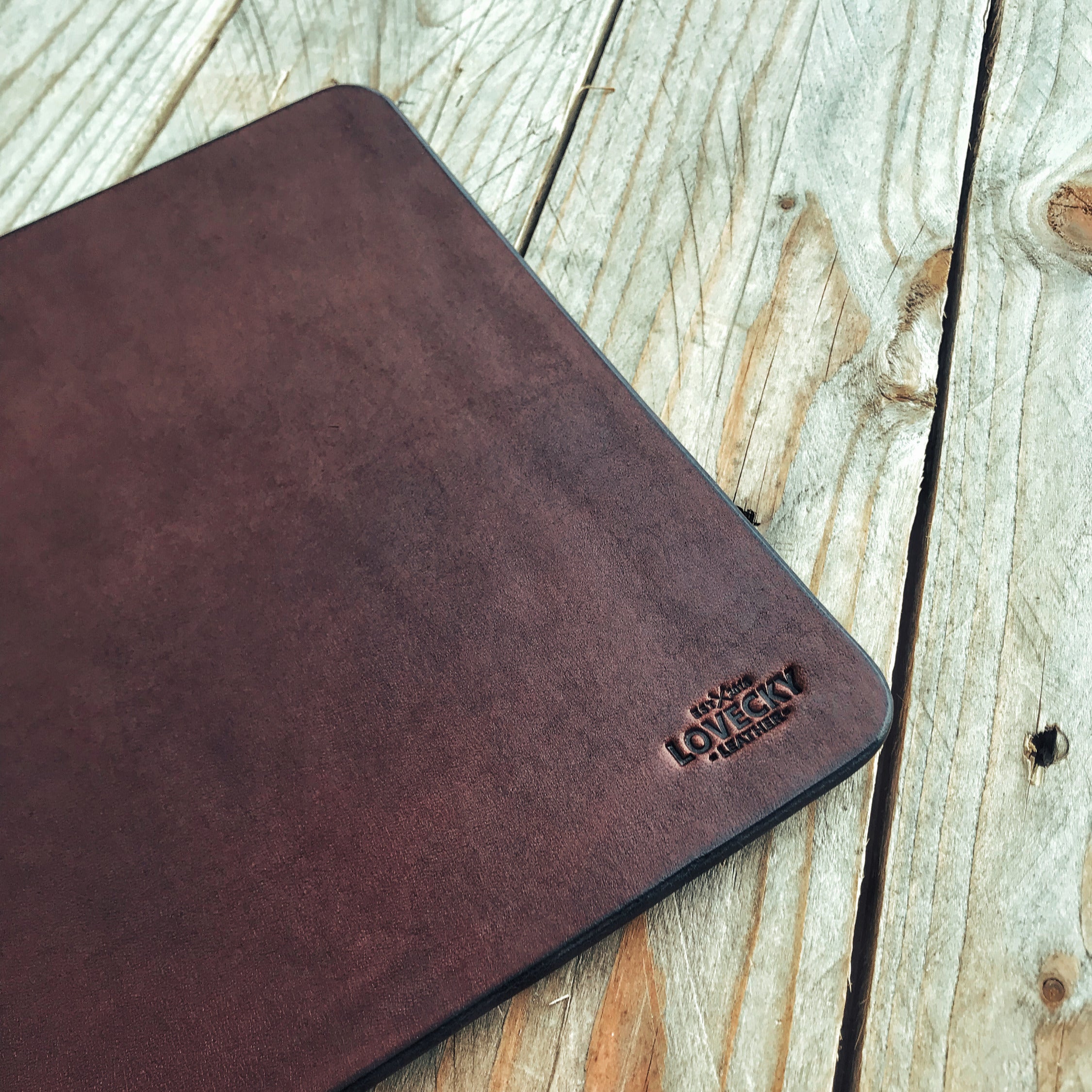 Lovecky Leather kožená podložka pod myš velikost L (35 × 22 cm) v tmavě hnědé barvě – detail loga a struktury pravé kůže.