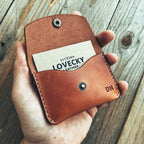 Lovecky Leather malá kožená peněženka 52 ve světle hnědé barvě, držená v ruce, ruční výroba z pravé kůže s gravírovaným monogramem, vhodná na karty a mince.
