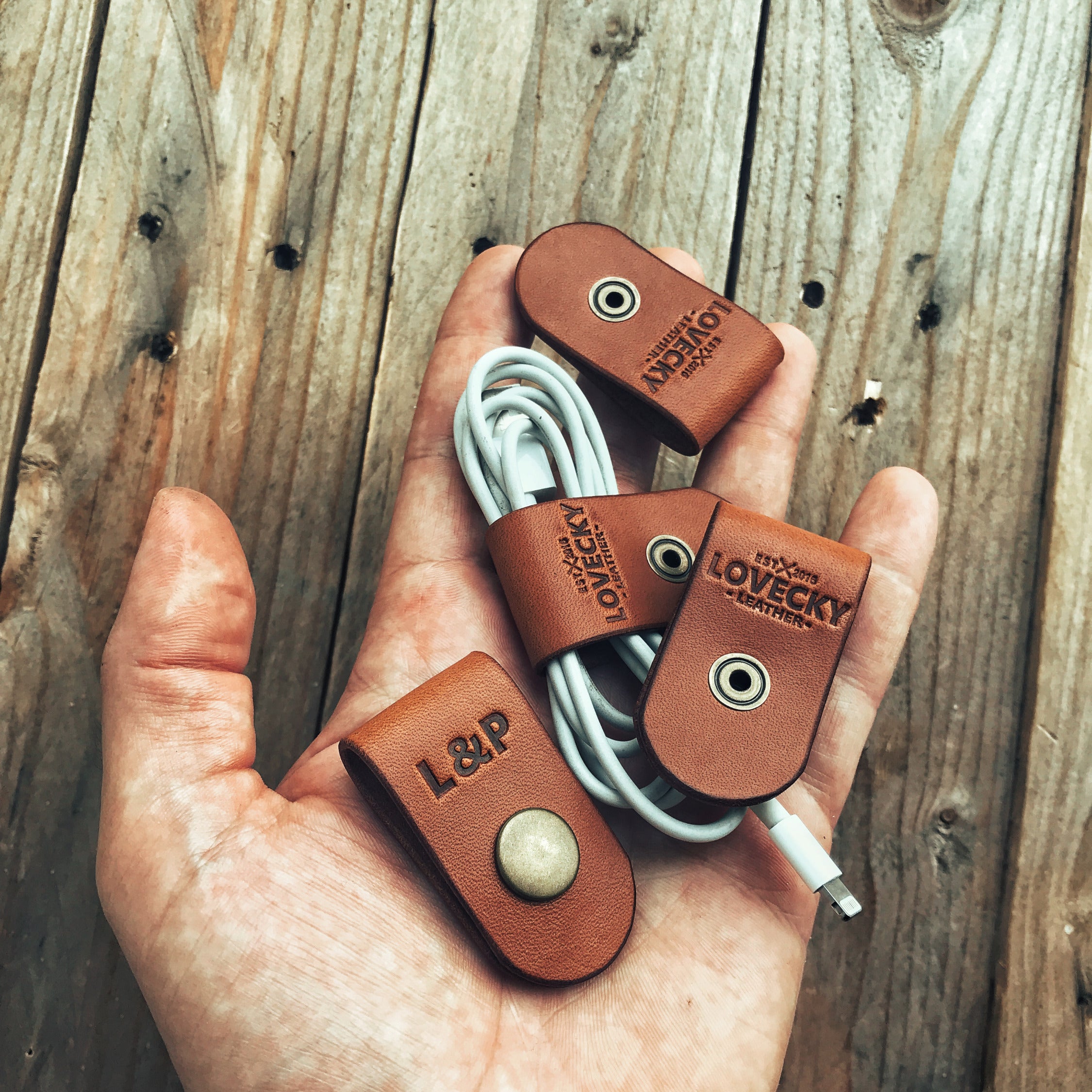 Lovecky Leather kožený organizér na sluchátka ve světle hnědé kůži s ražbou loga a monogramu.