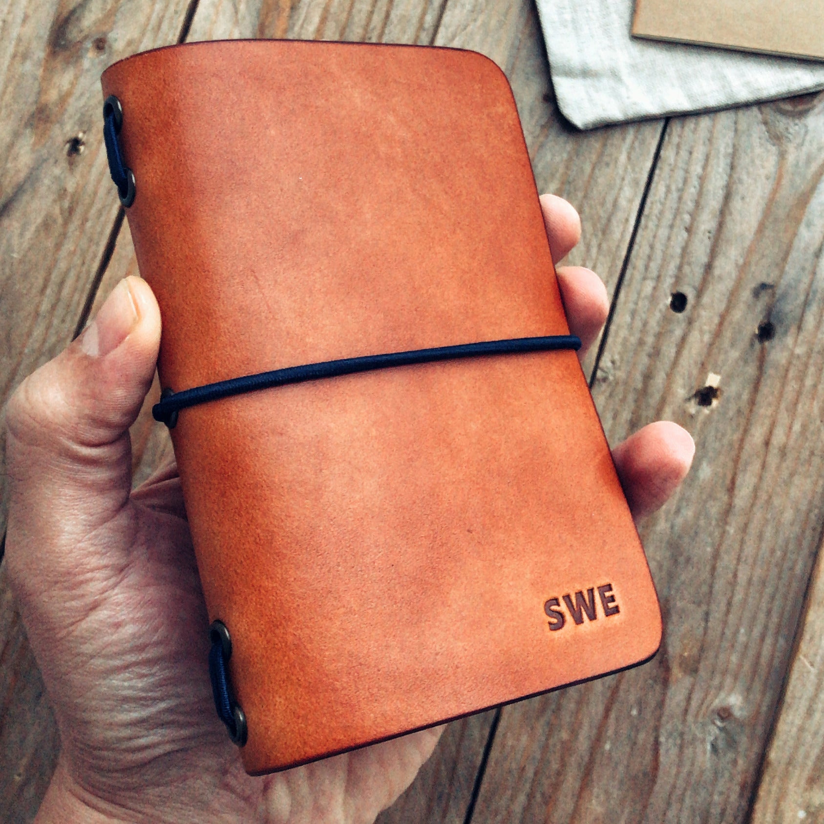 Lovecky Leather ručně vyrobený kožený obal 77 na diář a sešit A6, detail přední strany s gumičkou.