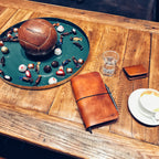 Lovecky Leather stylový kožený obal 77 na diář položený na stole, elegantní ruční výroba z hnědé kůže.