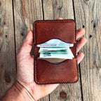 Světle hnědá peněženka 59 – otevřená v ruce, s bankovkami a doklady